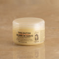 100ml Jar of Nilotica Shea Butter on a Brown Background