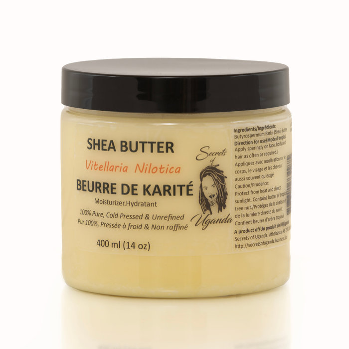 Secrets of Uganda tube on clean cream surface beside a shea nut